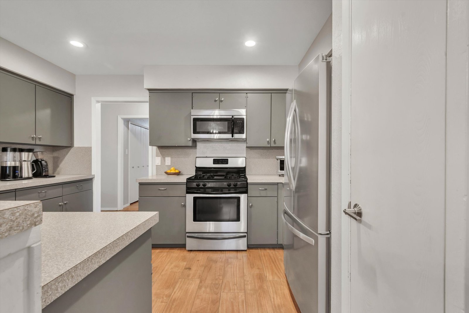 Kitchen from pantry door — gas range, microwave, French door refrigerator, gray cabinets and counter