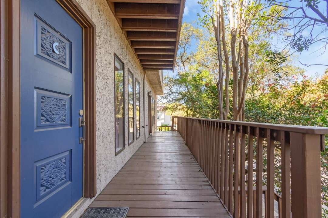 Entry deck with blue door surrounded by trees