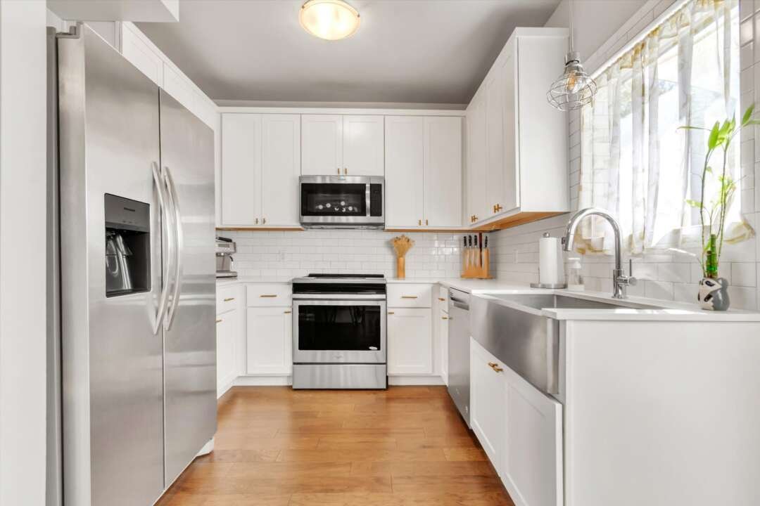 Kitchen — white shaker cabinets, quartz counters, farmhouse sink