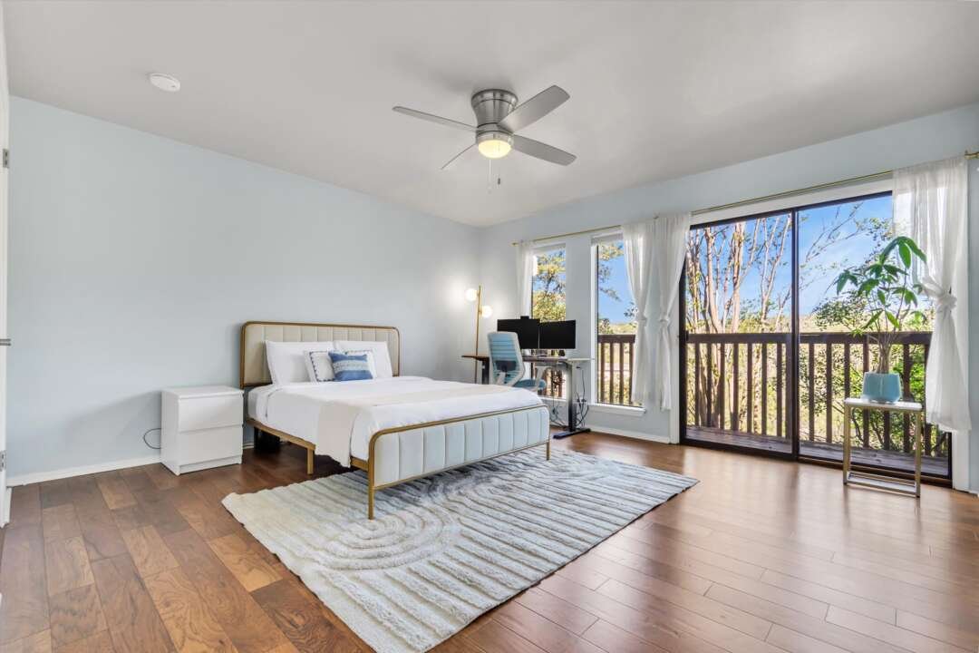 Primary suite with balcony and treetop views