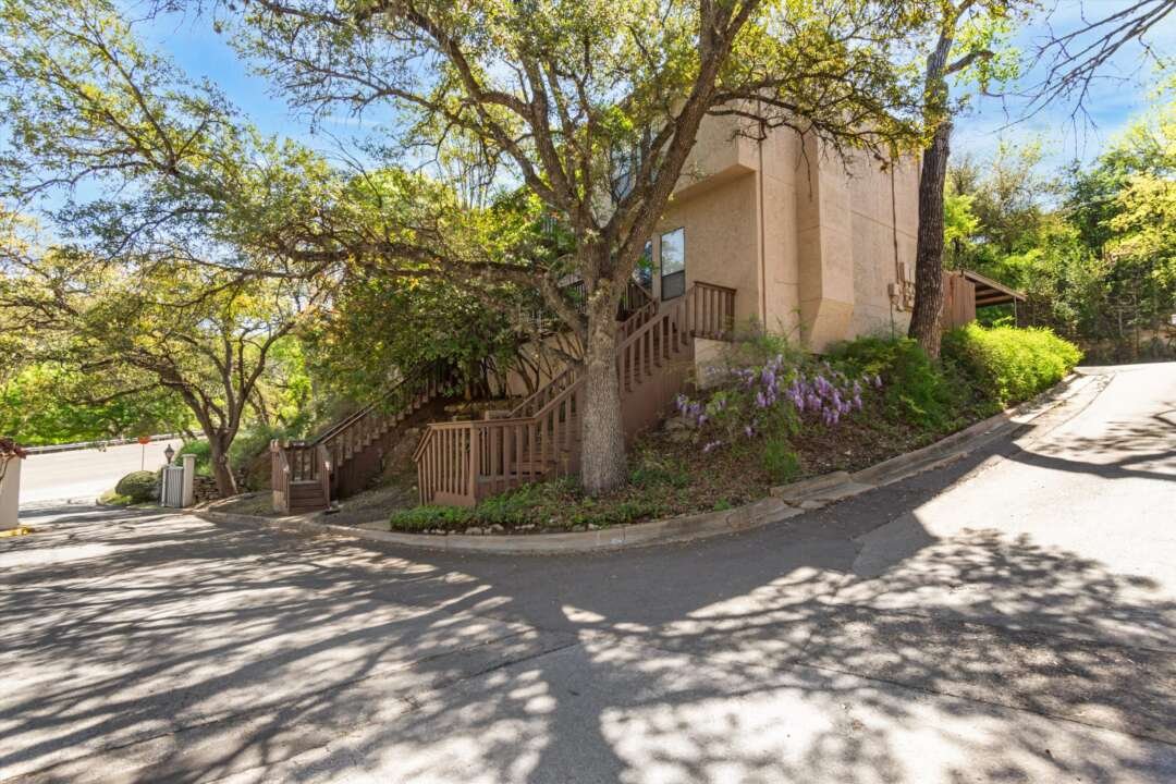 Front of unit with wisteria and mature trees in spring