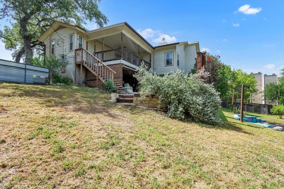 Back of the home with covered porch and large backyard