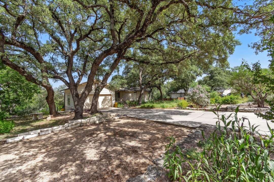 Front curb appeal of 6929 Chinook Dr under mature oak trees