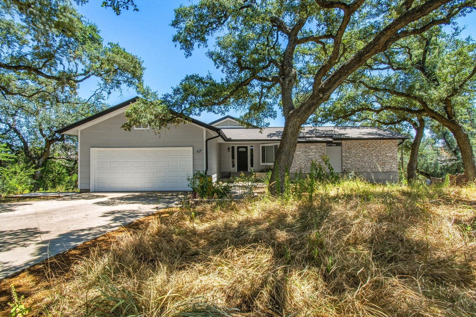 Freshly painted front of 6929 Chinook Dr under mature oak trees