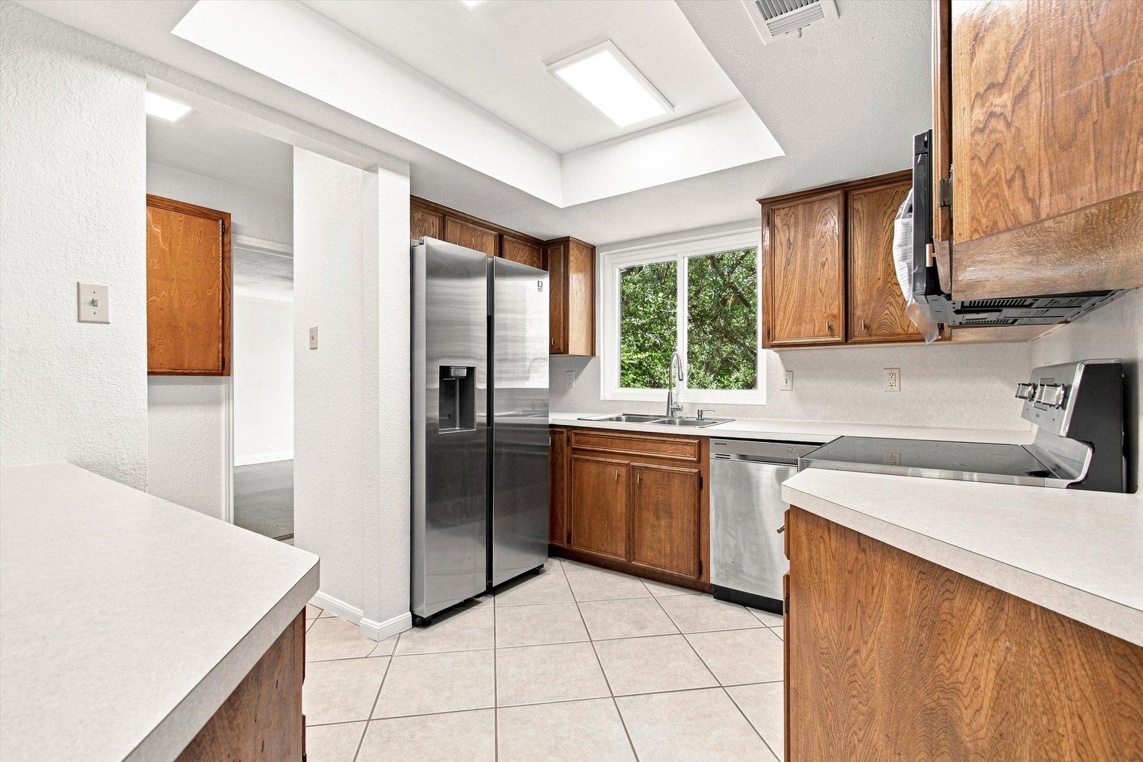 Kitchen with side-by-side stainless refrigerator and tile flooring