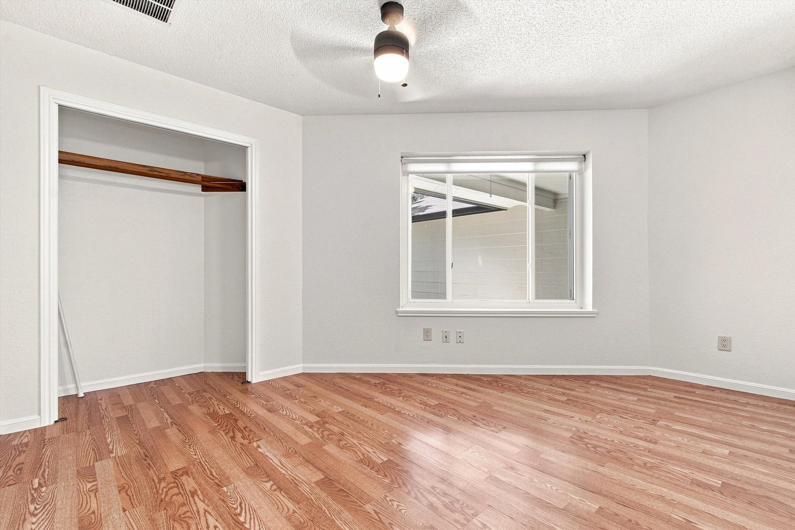 Guest bedroom with wide closet and hardwood floors