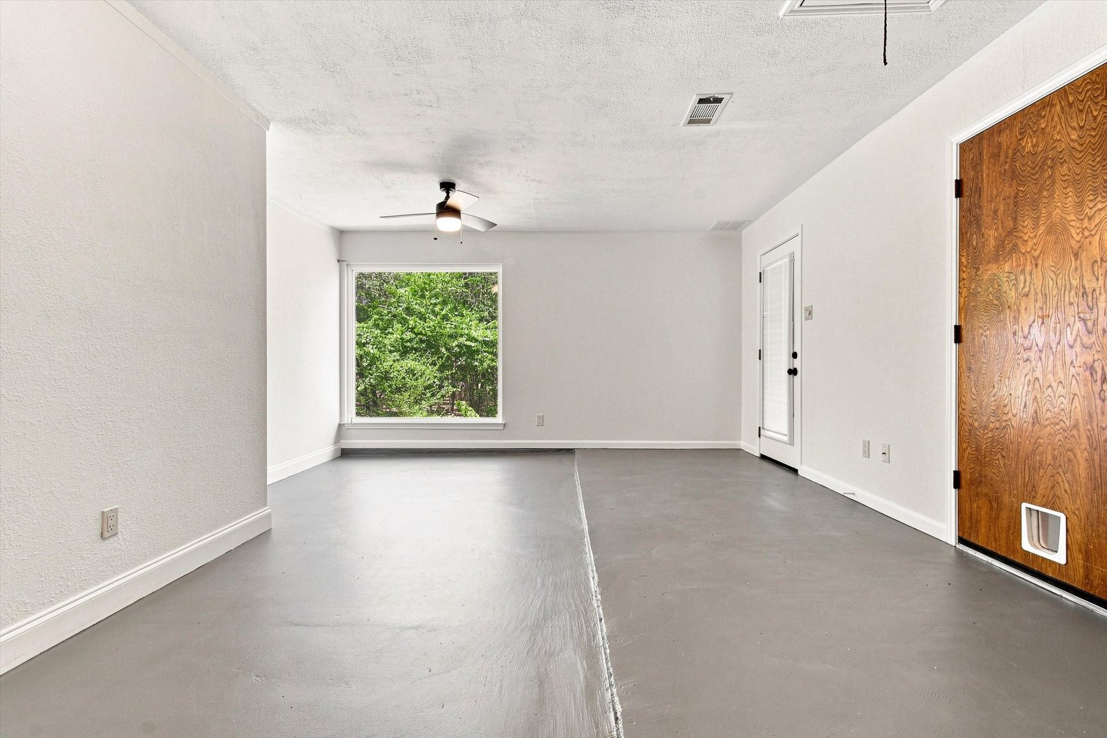 Bonus room with ceiling fan, large window, and exterior door